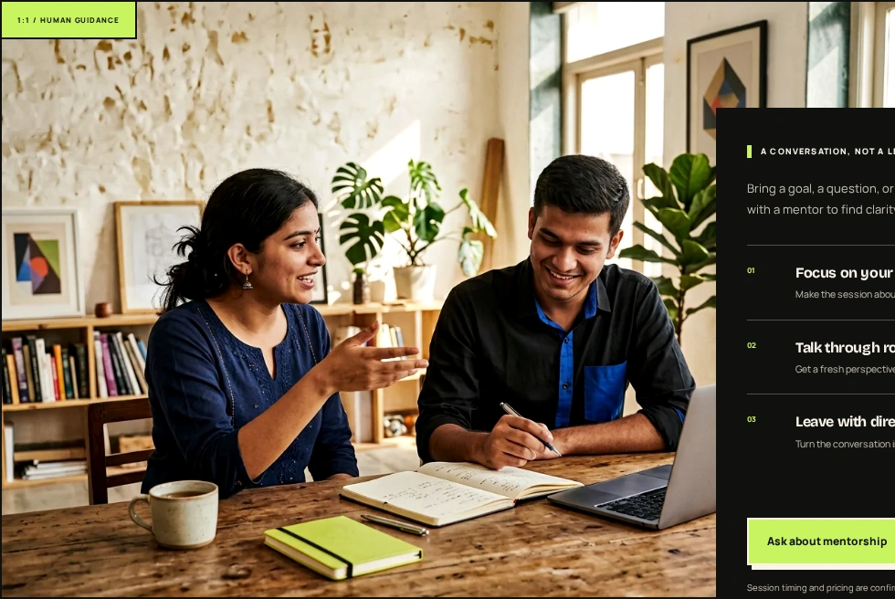 Two product teammates reviewing work together beside a laptop and notebook